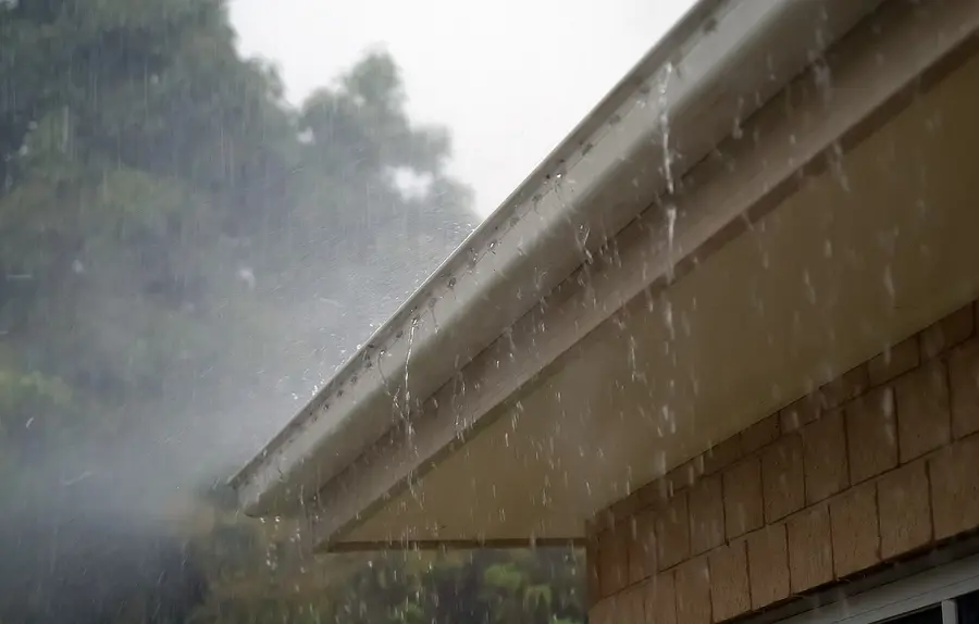 Rain pouring off a roof edge during a storm