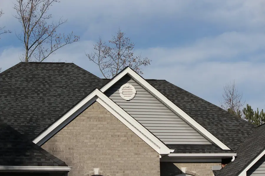 Shingle roofline with gutters on a brick and siding home
